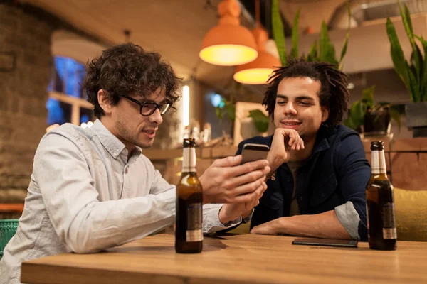 Homens com smartphones bebendo cerveja no bar ou pub — Fotografia de Stock