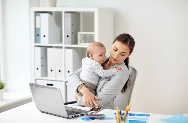Donna d'affari con bambino e smartphone in ufficio — Foto Stock