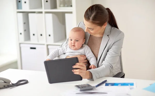 Zakenvrouw met baby en tablet pc op kantoor — Stockfoto