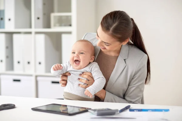 Feliz mujer de negocios con el bebé trabajando en la oficina — Foto de Stock