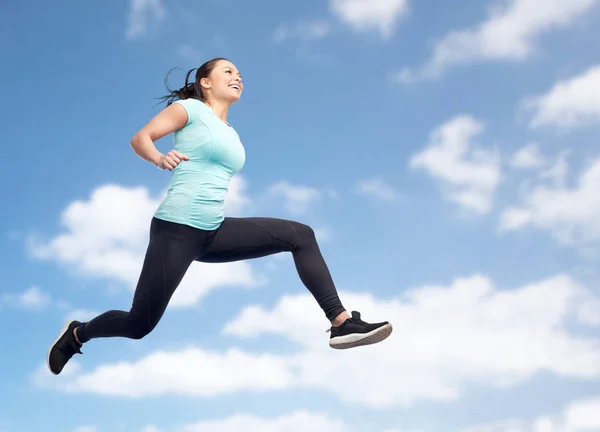 Happy smiling sporty young woman jumping in air — Stock Photo, Image