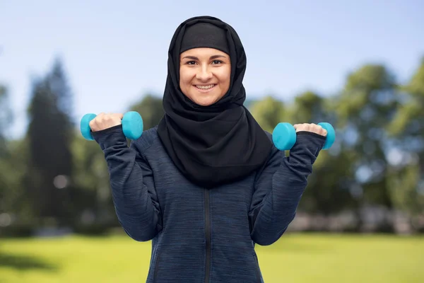 Mulher muçulmana em hijab com halteres fazendo fitness — Fotografia de Stock