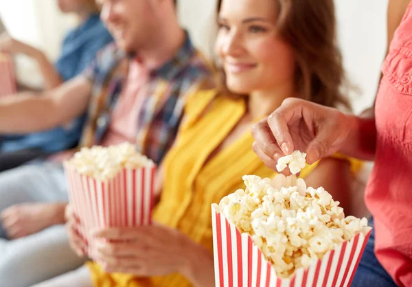 Close up of happy friends eating popcorn at home — Stock Photo, Image