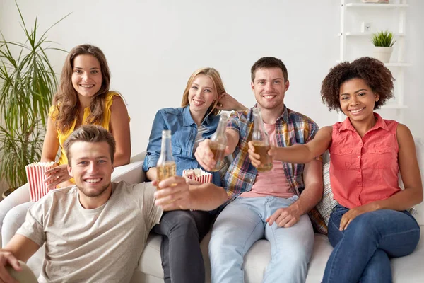 Amigos felices con palomitas de maíz y cerveza en casa — Foto de Stock