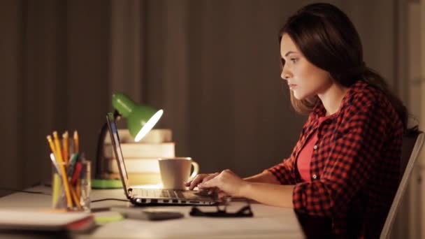 Студентка или женщина, печатающие на ноутбуке ночью дома — стоковое видео