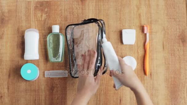 Manos embalaje bolsa de cosméticos para viajar — Vídeo de stock