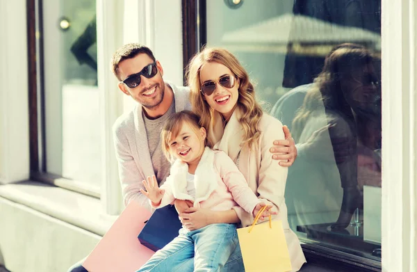 Gelukkig gezin met kind en boodschappentassen in stad — Stockfoto