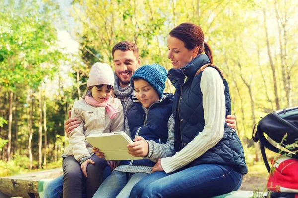 Familia feliz con tableta PC y mochilas en el campamento — Foto de Stock