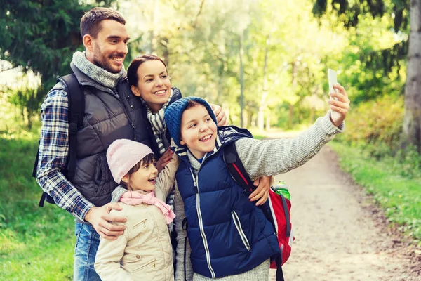 Family with backpacks taking selfie by smartphone — Stock Photo, Image