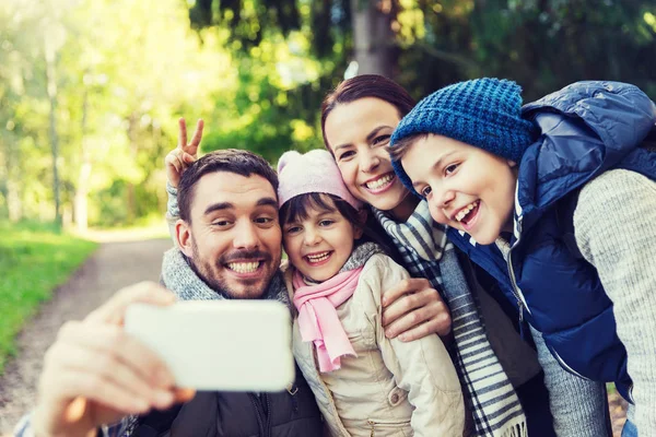 Family with backpacks taking selfie by smartphone — Stock Photo, Image
