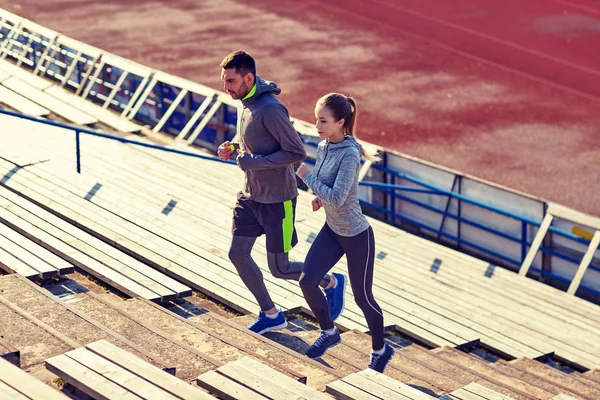 Couple running upstairs on stadium — Stock Photo, Image