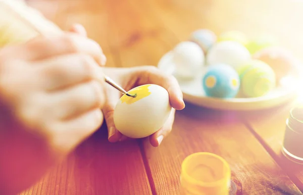 Close up of woman hands coloring easter eggs — Stock Photo, Image