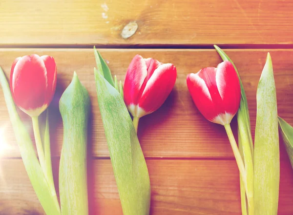 Nahaufnahme roter Tulpenblüten auf Holztisch — Stockfoto
