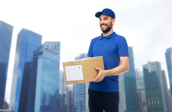 Счастливый доставщик с коробкой для посылок — стоковое фото