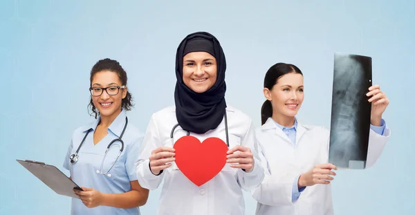 Médicos felices con corazón rojo, rayos X y portapapeles — Foto de Stock