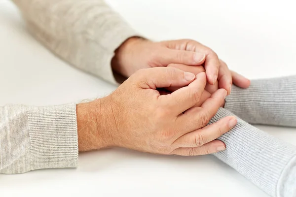 Nahaufnahme eines alten Mannes und einer jungen Frau beim Händchenhalten — Stockfoto