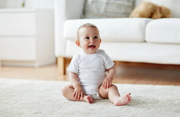 Menino ou menina feliz sentado no chão em casa — Fotografia de Stock