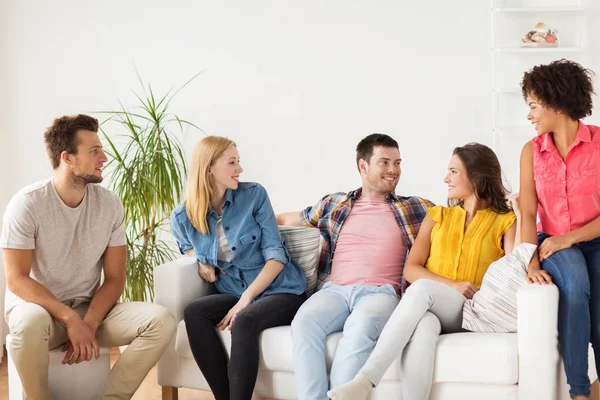 Группа счастливых друзей разговаривающих дома — стоковое фото