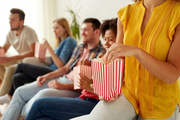 Zblízka happy přátel doma jíst popcorn — Stock fotografie
