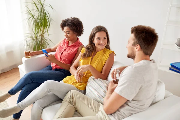 Grupo de amigos felizes com cerveja falando em casa — Fotografia de Stock