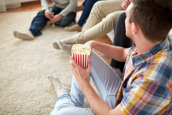 Close up of man with friends and popcorn at home — Stock Photo, Image
