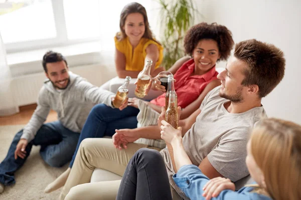 Groep gelukkige vrienden met dranken thuis praten — Stockfoto