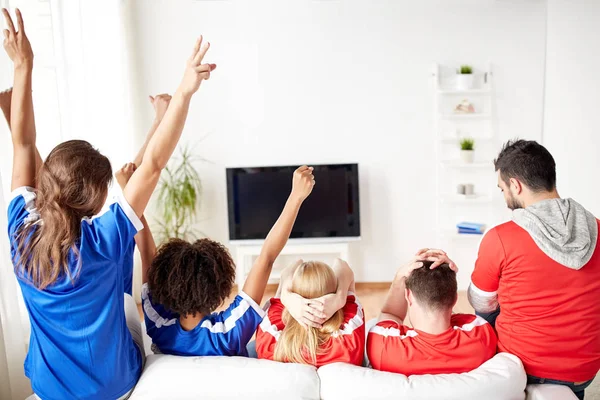 Друзья или футбольные болельщики смотрят телевизор дома — стоковое фото