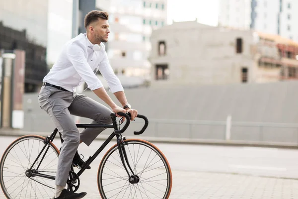 Hombre con auriculares a caballo bicicleta en la calle de la ciudad — Foto de Stock