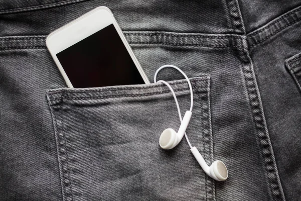 智能手机和耳机在牛仔或牛仔裤的口袋里 — 图库照片