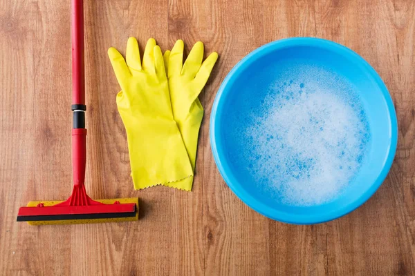 Bekken met het reinigen van spullen op houten achtergrond — Stockfoto