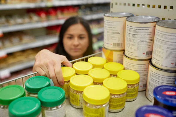 Mulher tomando frasco com alimentos da prateleira no supermercado — Fotografia de Stock