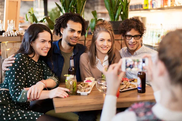 Друзья со смартфоном фотографируются в кафе — стоковое фото