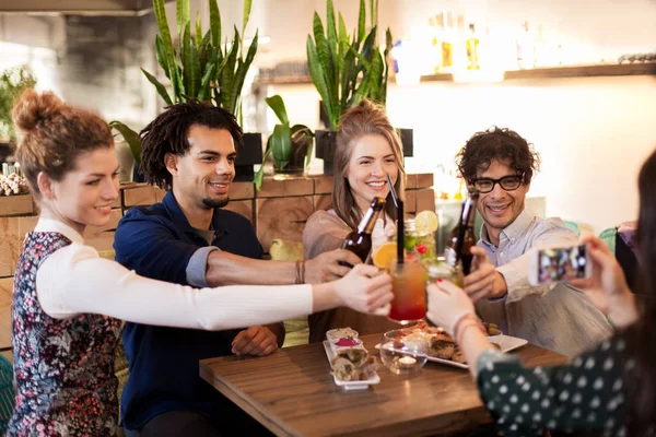 Amigos felices tintineo bebidas en el bar o cafetería — Foto de Stock