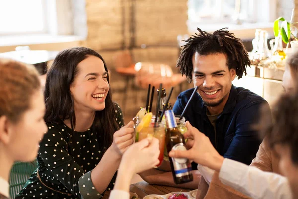 Amigos felizes batendo bebidas no bar ou café — Fotografia de Stock