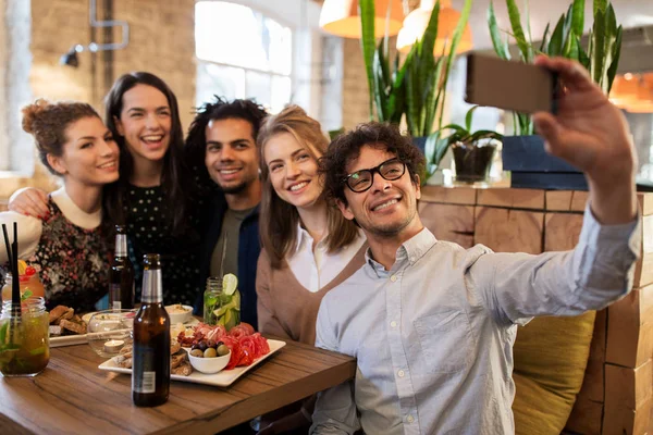 Amigos tomando selfie por smartphone no bar ou café — Fotografia de Stock