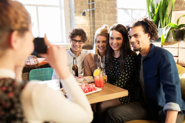 Amigos com câmera fotografando no bar ou café — Fotografia de Stock