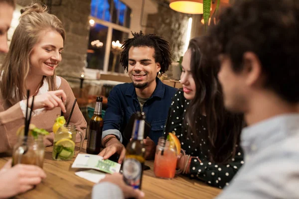 Amis avec boissons, argent et facture au bar — Photo