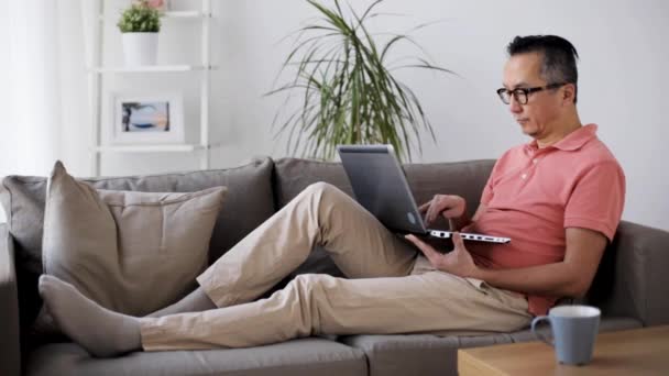 Man met laptopcomputer zittend op de Bank thuis — Stockvideo