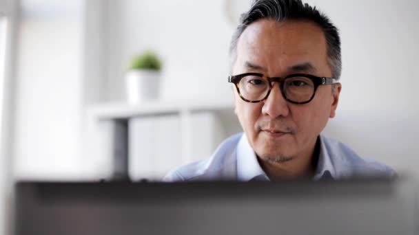 Businessman in eyeglasses with laptop at office — Stock Video