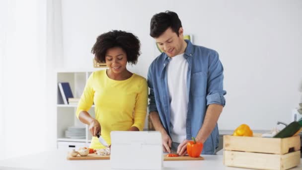 Feliz pareja con la tableta de cocina de la PC alimentos en casa — Vídeos de Stock