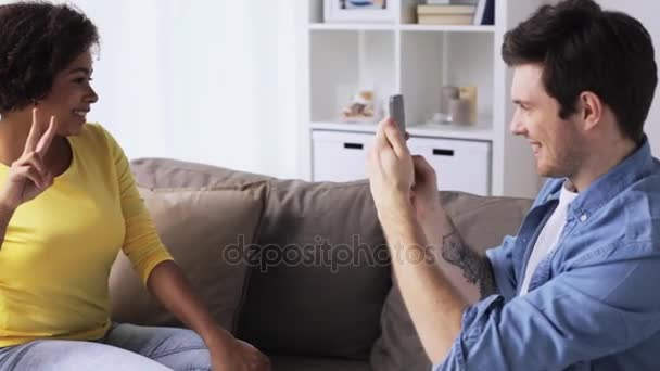 Счастливая пара со смартфоном, фотографирующая дома — стоковое видео