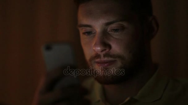 Молодий чоловік зі смартфоном вночі — стокове відео