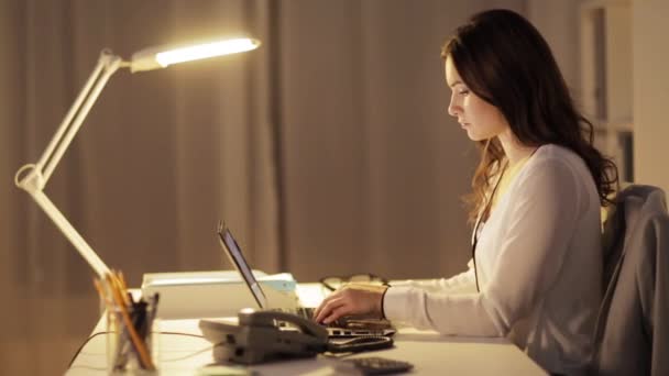 Mujer con portátil llamando por teléfono en la oficina de noche — Vídeo de stock