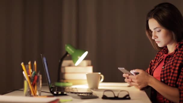Студентка с ноутбуком и смартфоном дома — стоковое видео