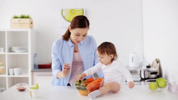 Madre y bebé con verduras en casa cocina — Vídeo de stock