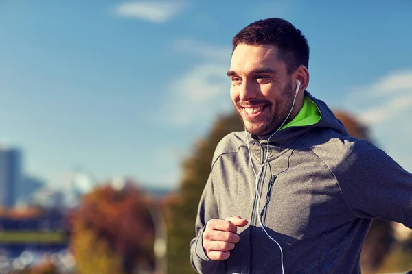 Šťastný muž se sluchátky běží v městě — Stock fotografie