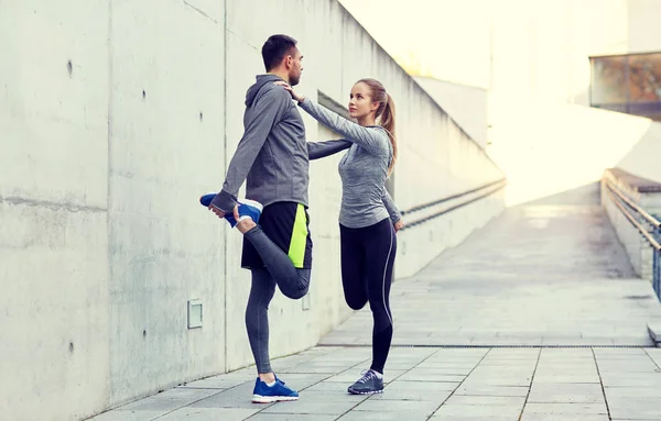 Lächelndes Paar streckt Bein im Freien — Stockfoto