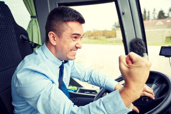 Сердитий водій, що показує кулак і водійський автобус — стокове фото