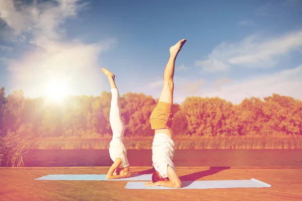 Par att göra yoga Huvudstående på matta utomhus — Stockfoto