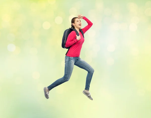 Femme heureuse ou étudiante avec sac à dos sautant — Photo